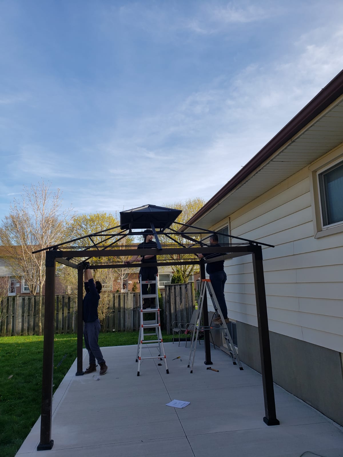 Gazebo assembly team near house